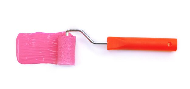 Photo brosse à rouleau avec peinture rose isolée sur blanc