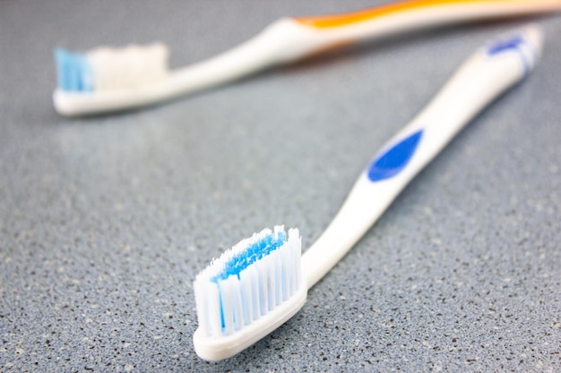 Brosses à dents accessoires personnels sur un évier de table bleu