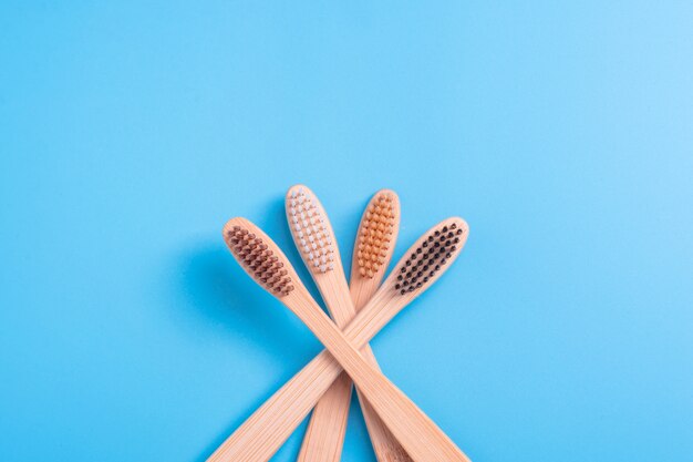 Brosses à Dents En Bambou Sur Fond Bleu. Hygiène Bucco-dentaire, Soins Des Dents Et Santé Respectueux De L'environnement. Produits De Nettoyage Pour La Bouche. Concept De Soins Dentaires.