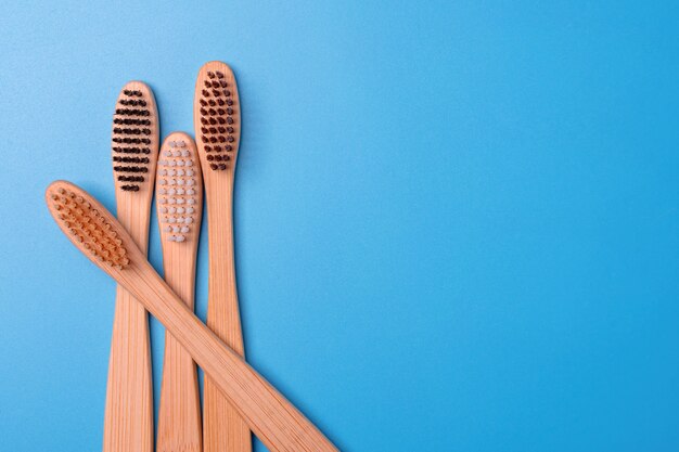 Brosses à dents en bambou sur fond bleu. Hygiène bucco-dentaire, soins des dents et santé respectueux de l'environnement. Produits de nettoyage pour la bouche. Concept de soins dentaires.