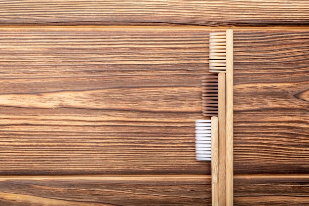 Brosses à dents en bambou sur fond de bois. Mise à plat avec espace de copie. Produits de bain naturels. Brosse à dents en bambou naturel biodégradable. Respectueux de l'environnement, zéro déchet, soins dentaires Concept sans plastique.