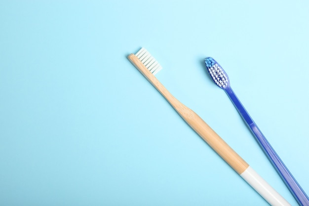 Brosses à dents en bambou naturel et plastique sur une vue de dessus de fond coloré