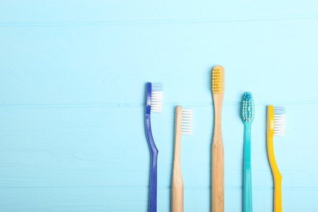 Brosses à dents en bambou naturel et plastique sur une vue de dessus de fond coloré