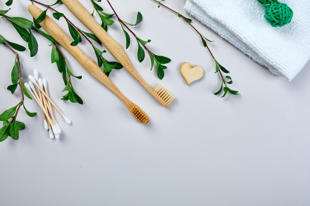 Brosses à dents et bâtons d'oreille en bambou et feuilles vertes, produits d'hygiène personnelle écologiques, zéro déchet, concept de soins dentaires