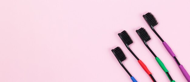 Brosses à dents écologiques en plastique biodégradable et charbon actif de bambou sur fond rose. Bannière avec espace copie