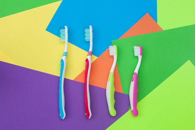 Brosses à dents sur fond clair coloré. Concept d'hygiène familiale.