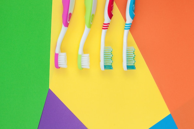 Brosses à dents sur fond clair coloré. Concept d'hygiène familiale.