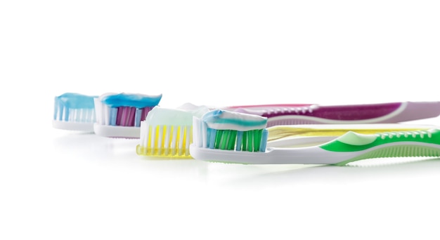 Brosses à dents avec de la pâte sur fond blanc