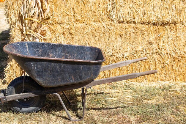 brouette devant une pile ou une balle de foin dans une ferme