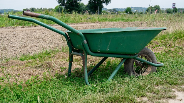 Brouette verte dans le champ cultivé