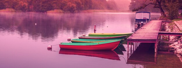 Brouillard d'automne tôt le matin Bateaux en bois à la jetée Bannière horizontale