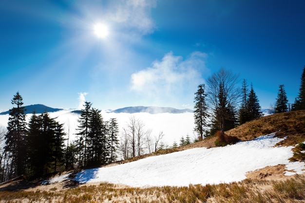 Brouillard blanc épais parmi les sommets des montagnes