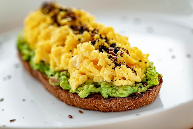 Brouillé sur toast avec guacamole et olives