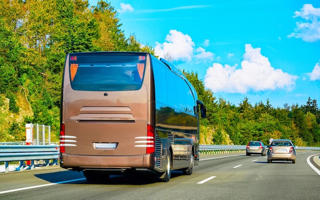 Photo brown shuttle bus retour en route, pologne. trafic de transport en commun moderne et route d'été. véhicule d'autocar de location en voyage de vacances. voyage de vacances pour les loisirs. mouvement et conduite urbaine.