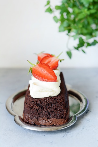 Brownie au chocolat avec crème à la vanille et fraises fraîches.