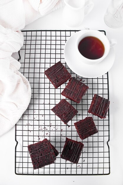 Brownie au chocolat et une tasse de thé sur la grille de support