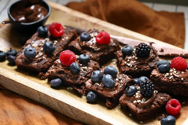 Brownie aux baies et chocolat sur une planche de bois Brownies végétaliens faits maison