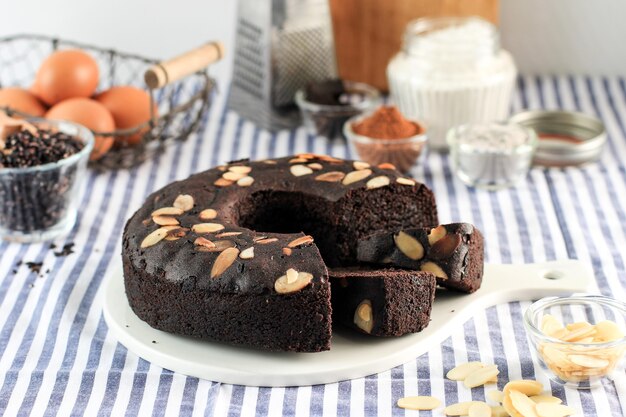 Brownies au chocolat Farine de riz gluant noir (Brownies Ketan Hitam) décoré d'une tranche d'amande sur fond sombre, espace de copie sur fond blanc