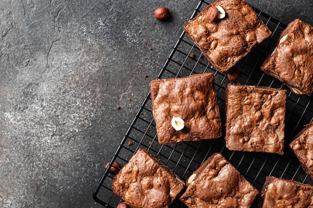 Brownies au chocolat avec des noix sur une grille de cuisson sur fond sombre espace de texte vue de dessus