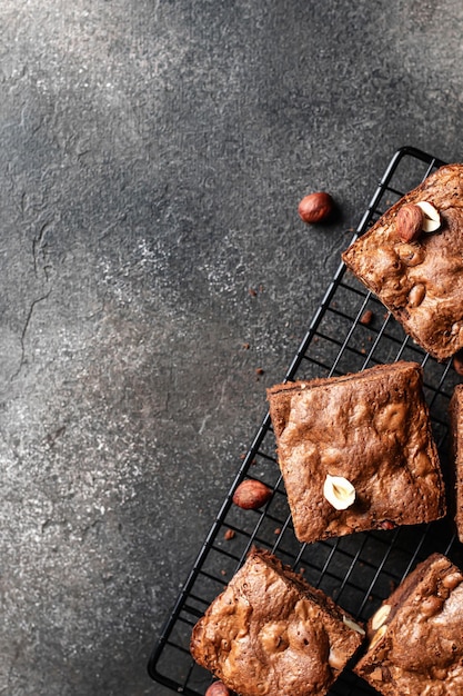 Brownies au chocolat avec des noix sur une grille de cuisson sur fond sombre espace de texte vue de dessus