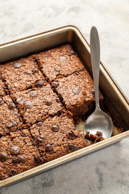Brownies à l'avoine cuits au four sains faits maison avec des pépites de chocolat dans une plaque de cuisson carrée
