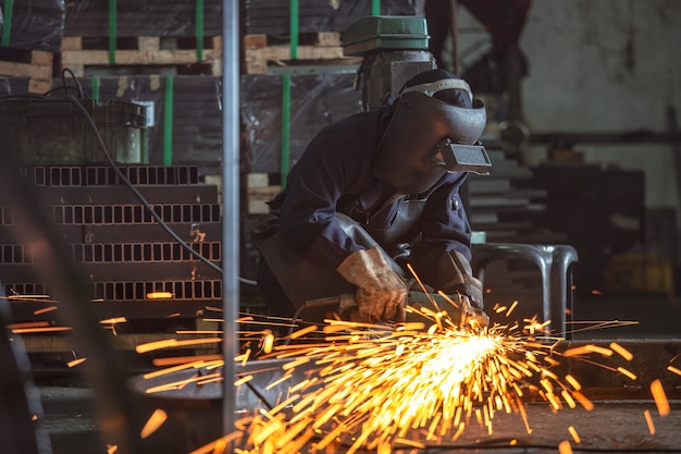 Broyage des roues électriques sur structure en acier et soudeuses à étincelles multiples en usine.