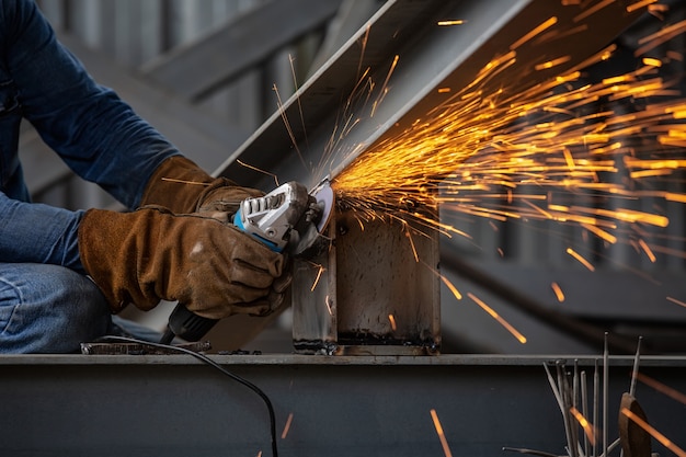 Broyage des roues électriques sur structure en acier et soudeuses à étincelles multiples en usine.