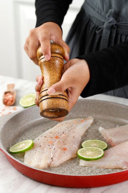 Broyer le poivre noir en filet de viande de poisson désossé