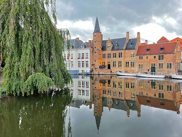 Bruges au coucher du soleil, la refection du batiment et la tour dans l'eau du canal. Style traditionnel