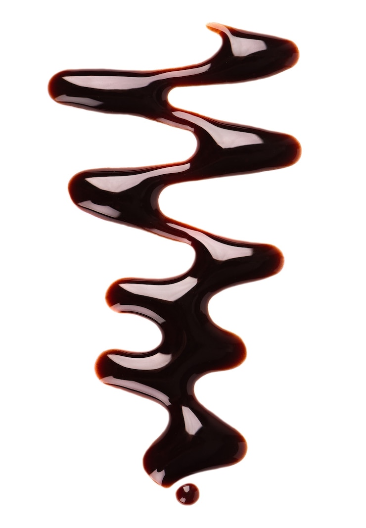 Photo bruine de sirop de chocolat isolé sur fond blanc. éclaboussures de sauce au chocolat sucré. vue de dessus.
