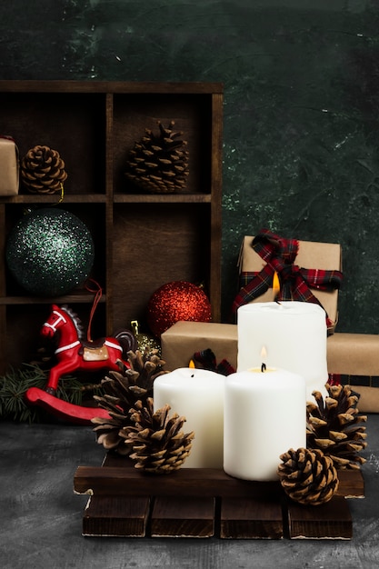 Brûler des bougies et des attributs de Noël sur une surface sombre