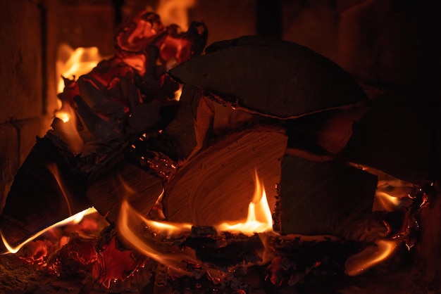 Photo brûler du bois de chauffage et du papier dans le gros plan du chauffe-brique le processus de combustion du bois