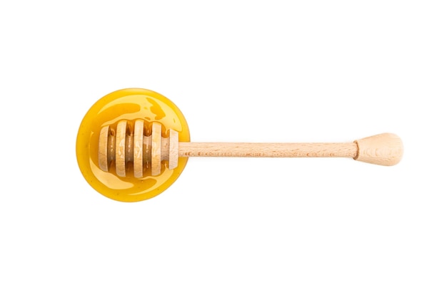 Un brumisateur de miel en bois avec une flaque de miel. Pris en studio avec une marque 5D III.