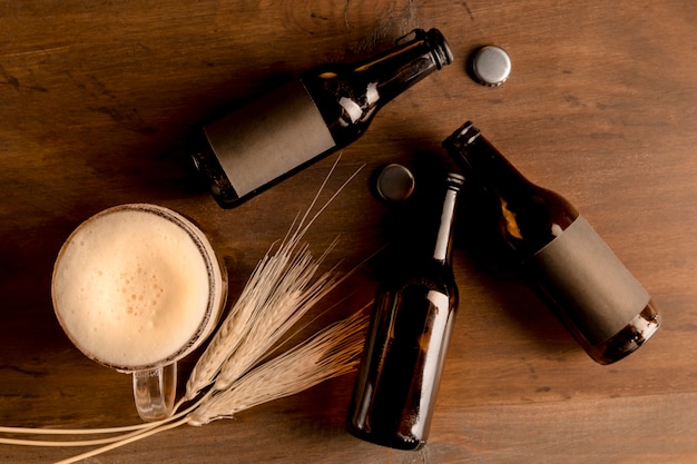 Photo brun bouteilles de bière avec un verre de bière dans une table en bois