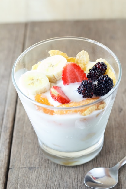 Brunch: verre de yaourt fait maison avec des céréales, fraise, banane, mûre, orange et muesli. Petit-déjeuner sain.