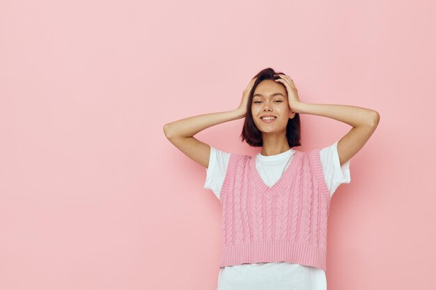 Brune aux cheveux courts dans un gilet rose posant fond isolé de vêtements décontractés