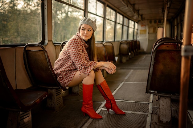 Brune dans une casquette et des bottes rouges Assis sur la selle dans le vieux tram