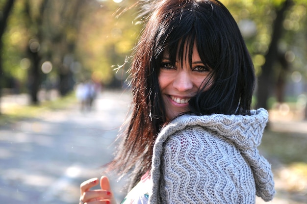 brune mignonne jeune femme souriante à l'extérieur dans la nature