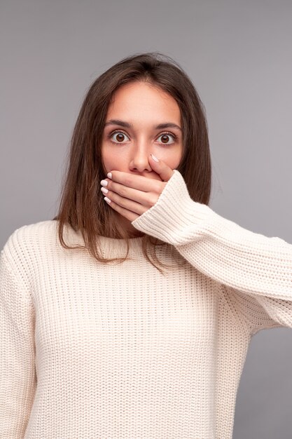 Brune stupéfaite couvrant le visage avec la main