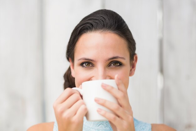 Brune stylée tenant une tasse