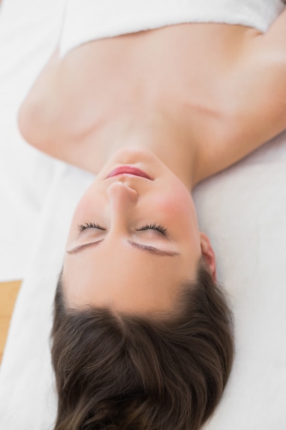 Brune sur la table de massage avec les yeux fermés