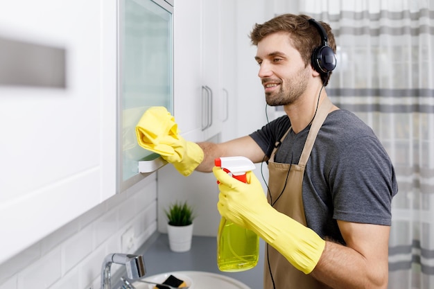 Brunet Lad nettoie la cuisine et écoute de la musique