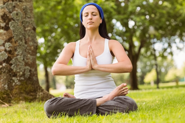 Brunette assis en lotus pose avec les mains ensemble