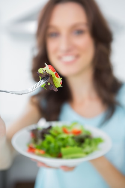 Brunette en bonne santé offrant une salade