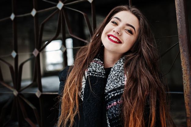 Brunette élégante fille décontractée en écharpe contre le lieu de l'usine abandonnée.