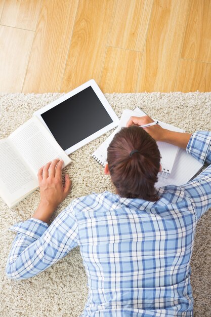 Brunette étudiante faisant des devoirs avec sa tablette