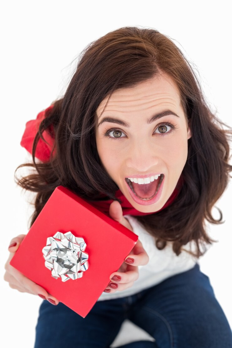 Photo brunette excitée assis tenant un cadeau rouge