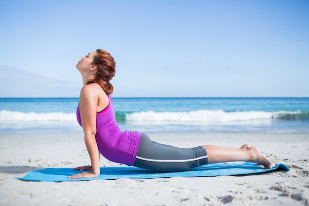 Brunette faire du yoga sur un tapis d&#39;exercice