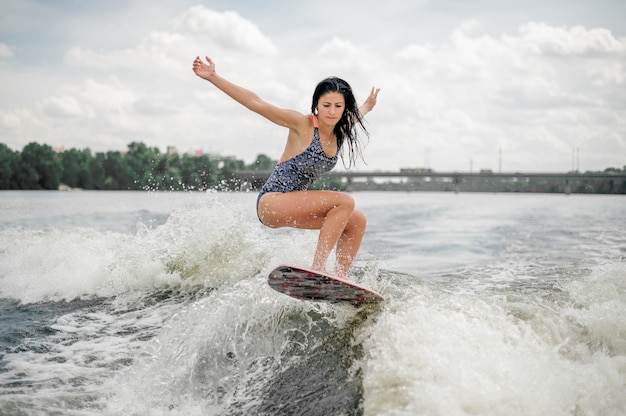 Brunette femme aux cheveux longs équitation wakeboard