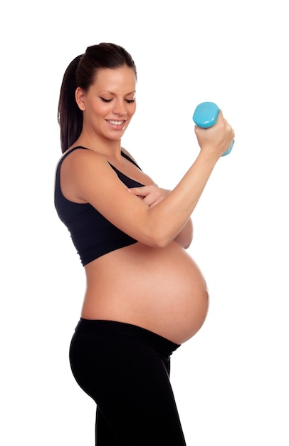 Brunette femme enceinte en formation avec des haltères